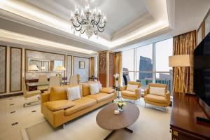 多哈Dusit Hotel & Suites - Doha的客厅配有沙发、椅子和吊灯