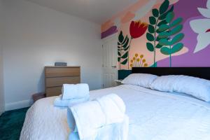 布里斯托3 bedroom home and garden in North Bristol的卧室配有白色床和毛巾