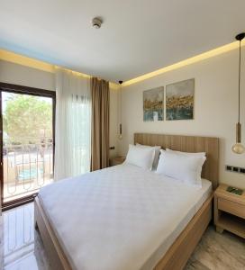 达利安Dna Hotel Dalyan的卧室设有一张白色大床和一扇窗户。