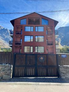 卡兹贝吉Kazbegi Apartments的一座带木门和围栏的房子