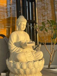 SatnaRadha Residency的坐在植物旁边的椅子上的白色雕像