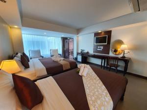 清迈Goldenbell Hotel Chiangmai的酒店客房,设有两张床和一张沙发