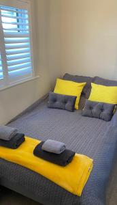 兰辛HenreeenOnWidewater的床上有黄色和灰色的枕头