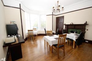 DalneighKinnoch Lodge的一间带桌椅和壁炉的用餐室
