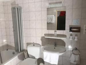 博帕德莱茵鲁斯特酒店的浴室配有卫生间、盥洗盆和浴缸。