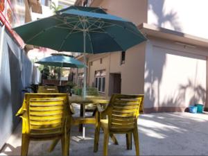KakarvittaHotel Quality的一张桌子、两把椅子和一把绿色雨伞