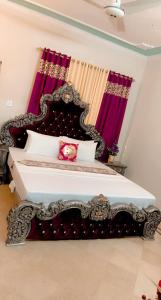 伊斯兰堡Galaxy Lodge的一间卧室配有一张黑色和白色的床,配有紫色窗帘