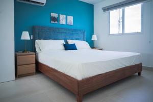 博卡奇卡Hermosa townhouse boca paraíso的一间卧室设有一张蓝色墙壁的大床