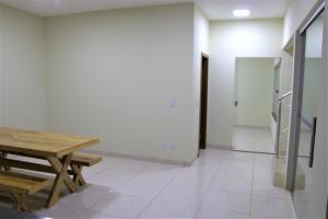 沙帕达-杜斯吉马朗伊斯Sobrado espaçoso com piscina com ar na suite的客房设有木桌和楼梯。