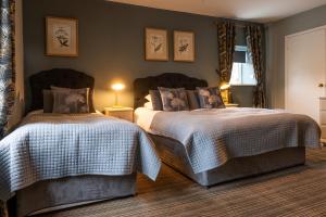 水上伯顿切斯特豪斯酒店的一间卧室设有两张床和窗户。