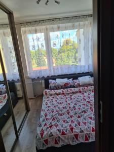卡尔帕奇Apartament u Maryśki的一间卧室配有一张带红白色棉被的床