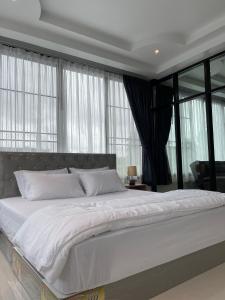 南邦Service Apartment ใจกลางเมืองใกล้แหล่งท่องเที่ยว119ทับ1ถนนปงสนุก的卧室设有一张带窗户的白色大床