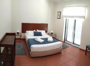 Faja GrandeCasa dos Salgueiros的一间卧室配有一张床,上面有两条毛巾