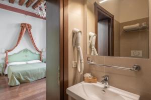 威尼斯Hotel al Sotoportego的一间带水槽和镜子的浴室以及一张床