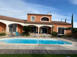 卡布列尔Villa en bordure de Garrigue的别墅前设有游泳池