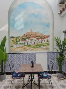 希梅纳德拉夫龙特拉Unique Village House的一张桌子、两把椅子和墙上的一幅画