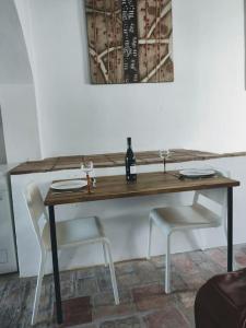 希梅纳德拉夫龙特拉Unique Village House的一张桌子、两把椅子和一瓶葡萄酒