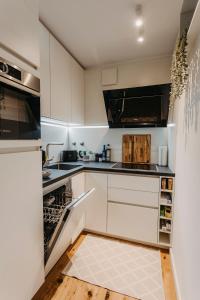 莱比锡Stylisches Apartment im Herzen Leipzigs mit Balkon的厨房配有白色橱柜和开放式洗碗机。