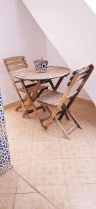 得土安Riad Soul of Tetouan的一张木桌、两把椅子、一张桌子和一张桌子