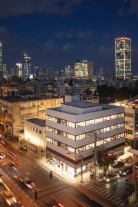 特拉维夫DeBlox living - Ben Avigdor Apartments的一座晚上与城市在一起的建筑