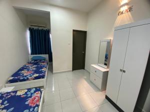 De’ Nuhir Homestay Teluk Senangin的一间带两张床的卧室和一台电视