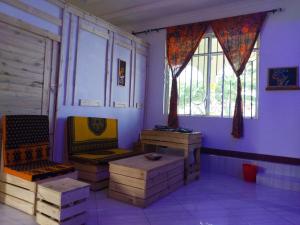 达累斯萨拉姆L&J Modern Backpackers Kigamboni Beach House的一间设有两把椅子和一张桌子的房间,窗户