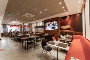 利马利马瑞度托米拉弗洛雷斯宜必思酒店的餐厅设有桌椅和平面电视。