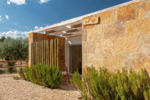 埃斯特雷莫斯Reflexos D'Alma Turismo Rural的一座砖砌建筑,在庭院里摆放着椅子