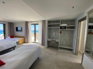 利勒鲁斯Hôtel L'Isula Marina的酒店客房设有两张床,享有海景。