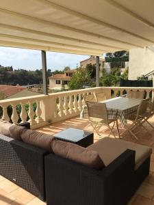 尼斯Villa Paradiso, logement avec piscine, Nice Nord的阳台配有沙发和桌椅。