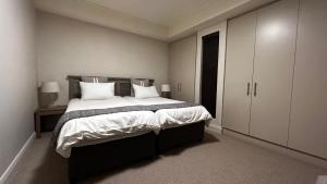 开普敦Canal Quays 507的卧室配有一张带白色床单和枕头的大床。