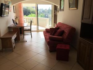 尼斯Villa Paradiso, logement avec piscine, Nice Nord的客厅配有红色的沙发和桌子