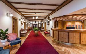 圣坎迪朵索雷天堂公园酒店的大堂铺有红地毯,配有椅子和酒吧