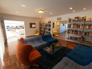 皮拉茹Casa francesa de Piraju的客厅配有蓝色的沙发和书架
