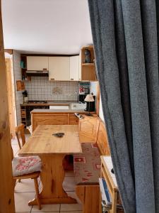 莱孔塔米讷蒙茹瓦潘博奈特公寓的厨房配有木桌和窗帘