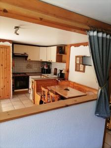 莱孔塔米讷蒙茹瓦潘博奈特公寓的厨房配有大型木桌和椅子