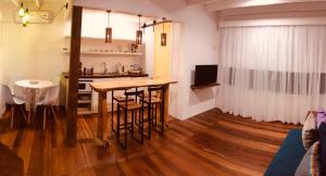 埃斯特角城Punta Ballena Punta del Este的厨房以及带桌椅的起居室。