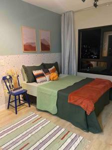 圣保罗F1604 COBERTURA na Frei Caneca com LINDA VISTA da Av Paulista的卧室配有床、椅子和窗户。