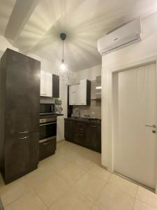 夸尔图-圣埃莱娜Civico 107的厨房配有黑色橱柜和白色门