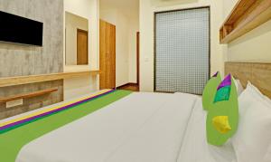 钱德加尔Treebo Trend Delmont的卧室配有白色的床和电视。
