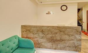 钱德加尔Treebo Trend Delmont的客厅配有绿色沙发和墙上的时钟