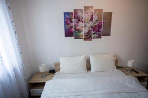 索非亚Karastoyanovi's apartment 2的卧室配有一张壁画和两张画的床铺。