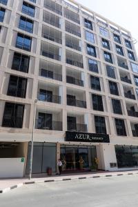 迪拜Azur Regency Hotel Apartments的一座大型公寓楼,上面有标志