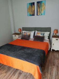 斯培西亚Decò & Retrò apartment的一间卧室配有一张带橙色毯子的大床