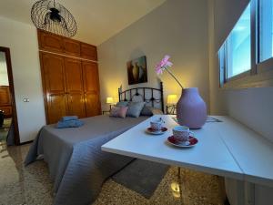Playa del BurreroSarah Kite II Vv, Room 1的一间卧室配有一张床和一张带花瓶的桌子