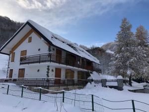利莫内皮埃蒙特La Baita Limone Riserva Bianca Ski-in Ski-out Seggiovia Morel 3的雪中带栅栏的房子