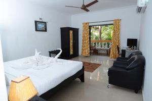 坎多林Silver Sands Sunshine - Angaara的卧室配有床、椅子和窗户。