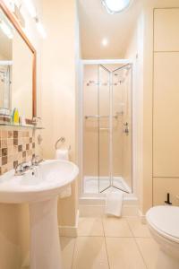 斯图尔特港安克雷奇旅馆的带淋浴和盥洗盆的白色浴室