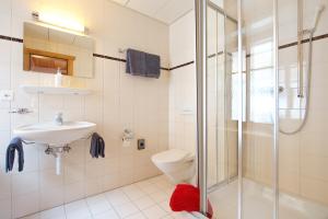 采尔马特班霍夫酒店的浴室配有卫生间、盥洗盆和淋浴。