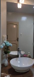 塔里哈Departamento El-Shaddai的浴室设有三个水槽和一个花瓶